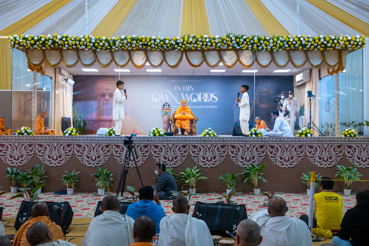 Children invite Swamishri for the evening assembly titled 'In His Own Words'