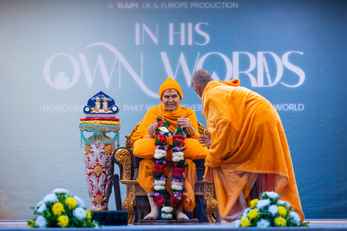 Anandswarup Swami honors Swamishri with a garland