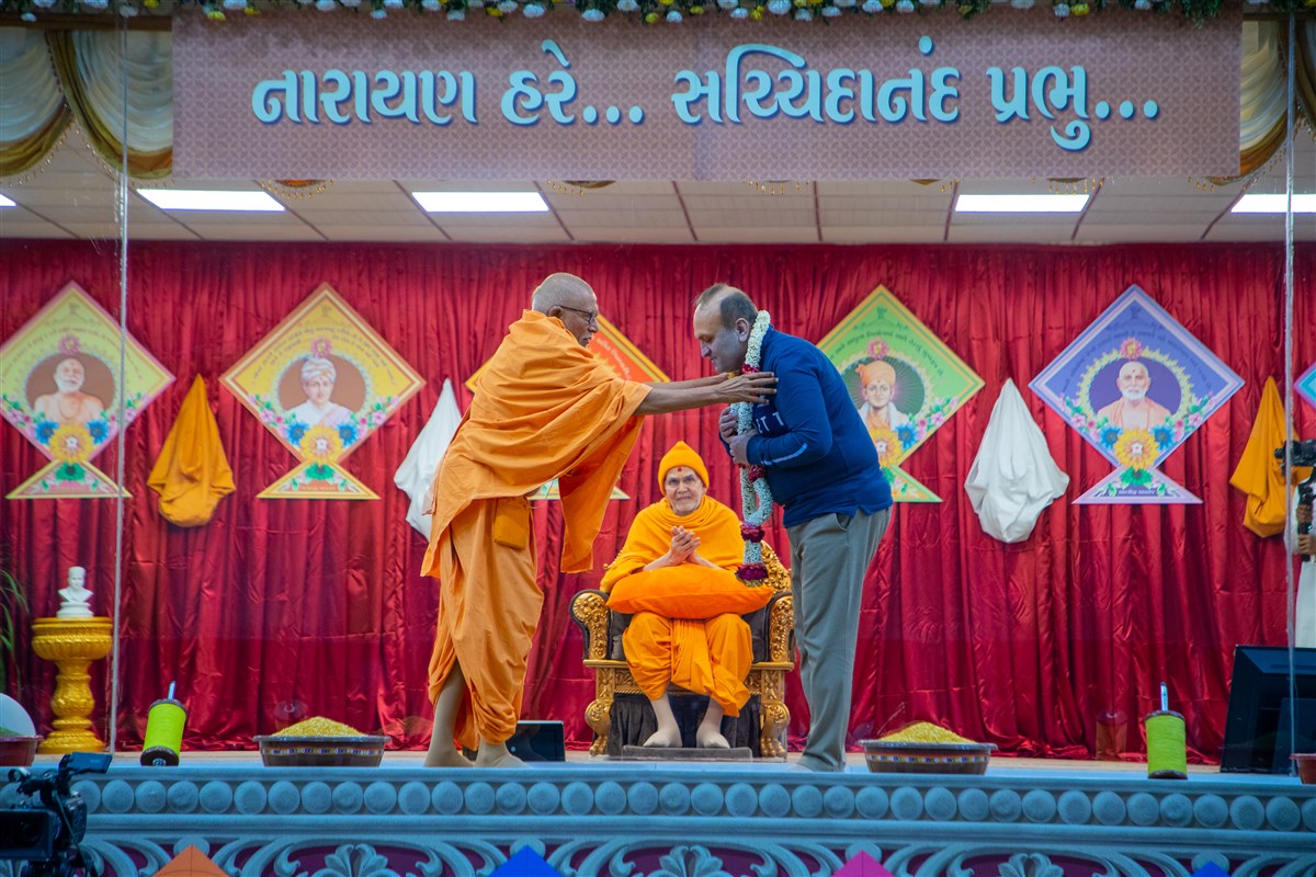 Pujya Kothari Swami honors Shri Yashwantbhai Jethva with a garland