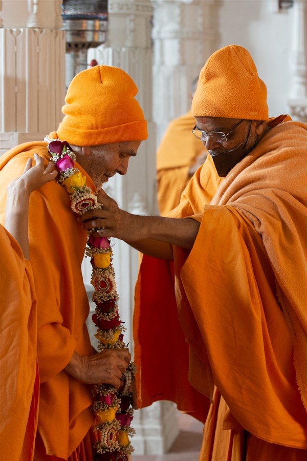 Gnaneshwar Swami welcomes Swamishri with a garland