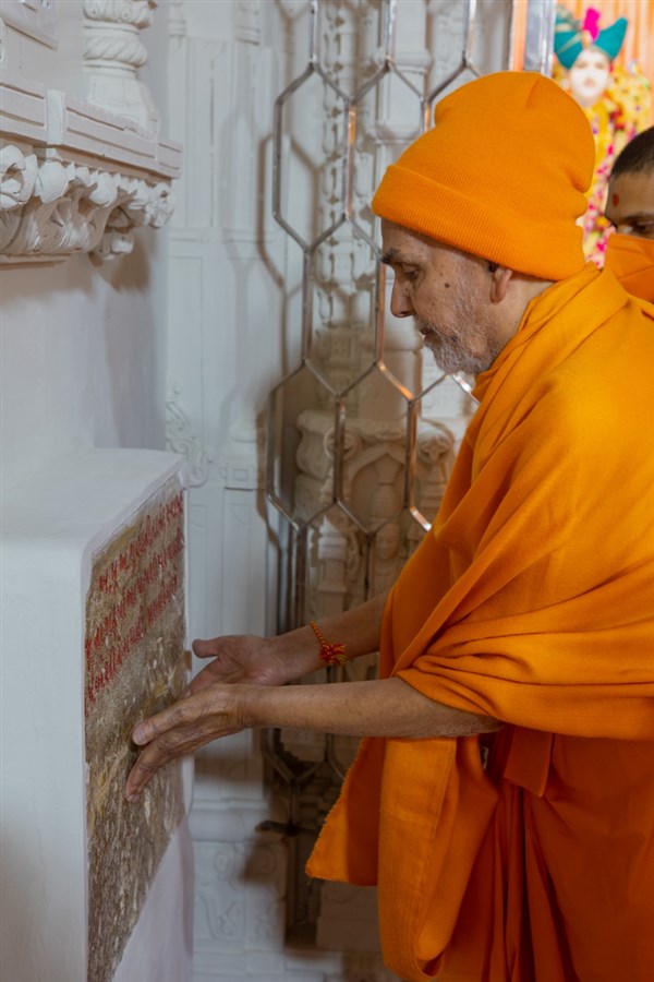 Swamishri engrossed in darshan of sacred stone sanctified by Aksharbrahma Gunatitanand Swami