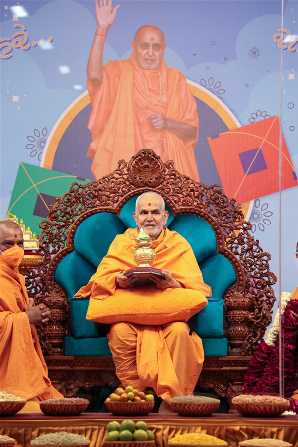 Swamishri holds a kalash