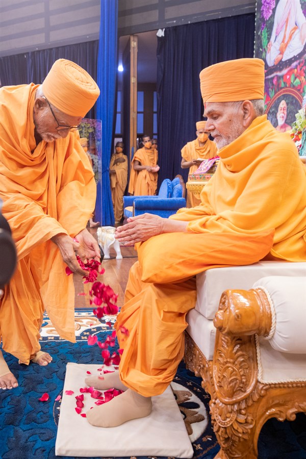 Pujya Kothari Swami welcomes Swamishri with flower petals