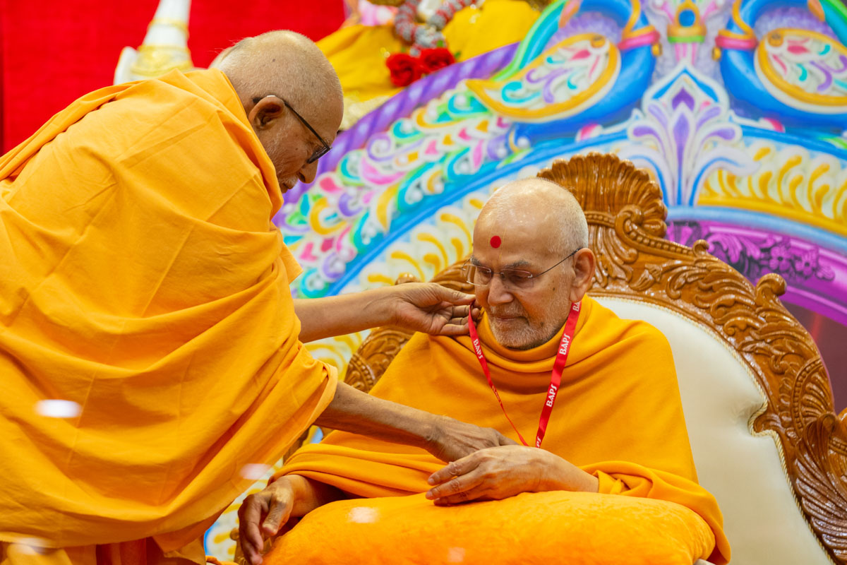 Pujya Kothari Swami honors Swamishri with an i-card