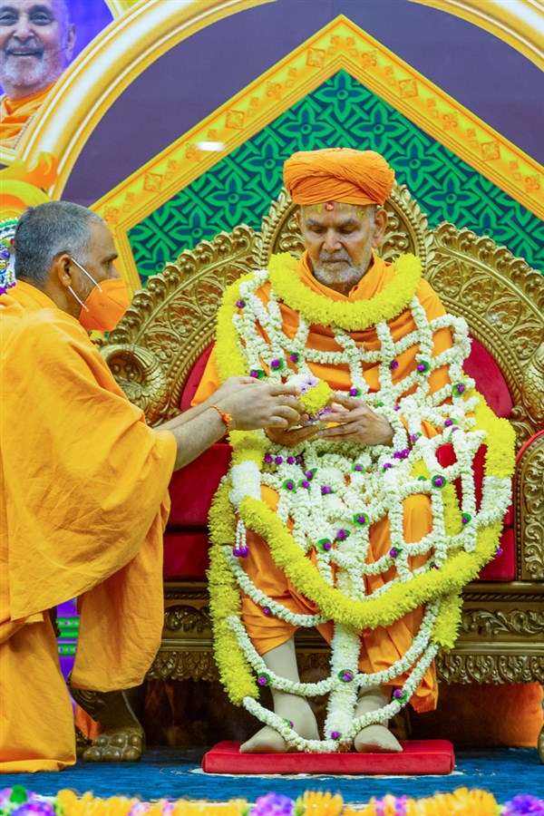 Swamishri honored with a flower shawl