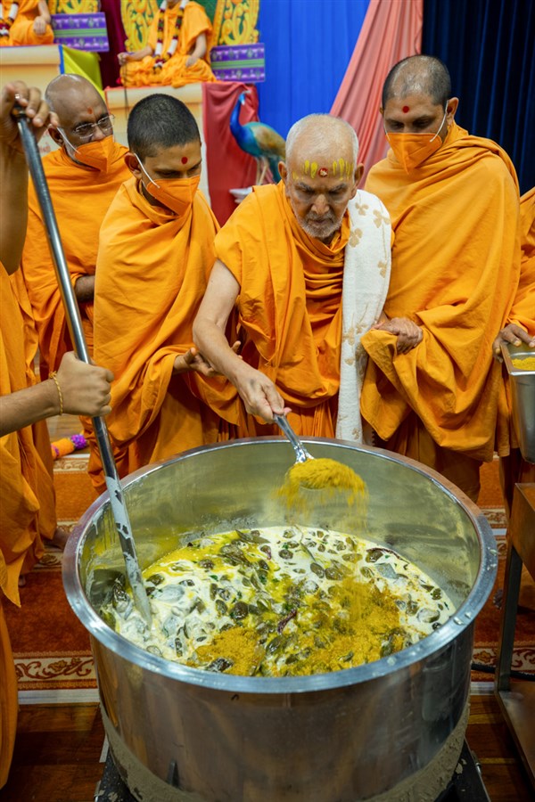 Swamishri adds ingredients to the shak mixture