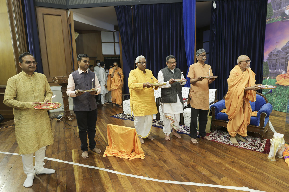 Pujya Kothari Swami and invited guests perform the arti