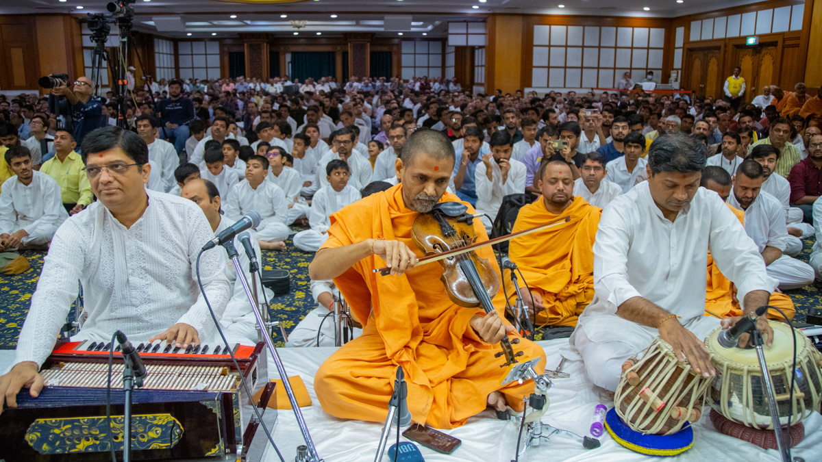 Pranavtirth Swami plays the violin in Swamishri's daily puja