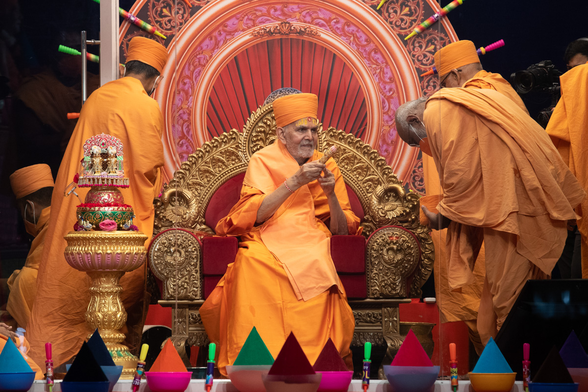 Swamishri sprays saffron-scented water on Abhayswarup Swami