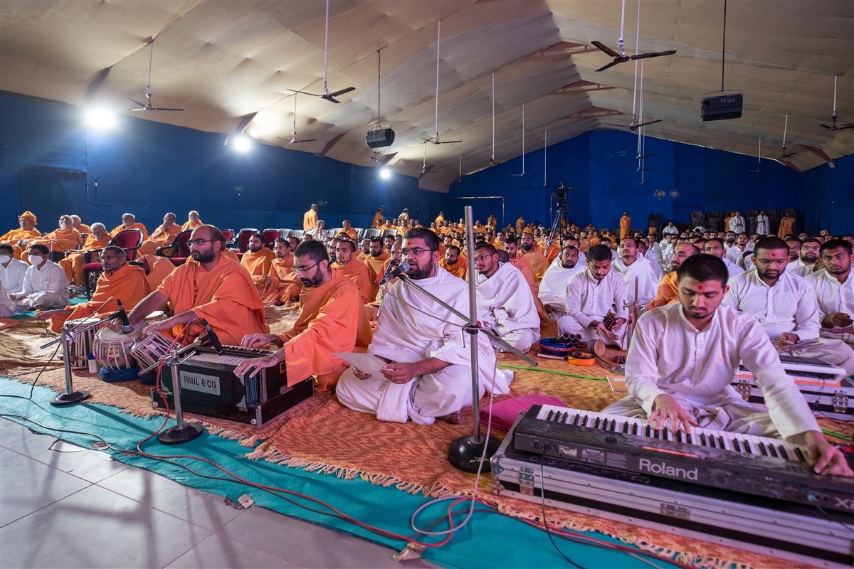 A parshad sings a kirtan in Swamishri's morning puja
