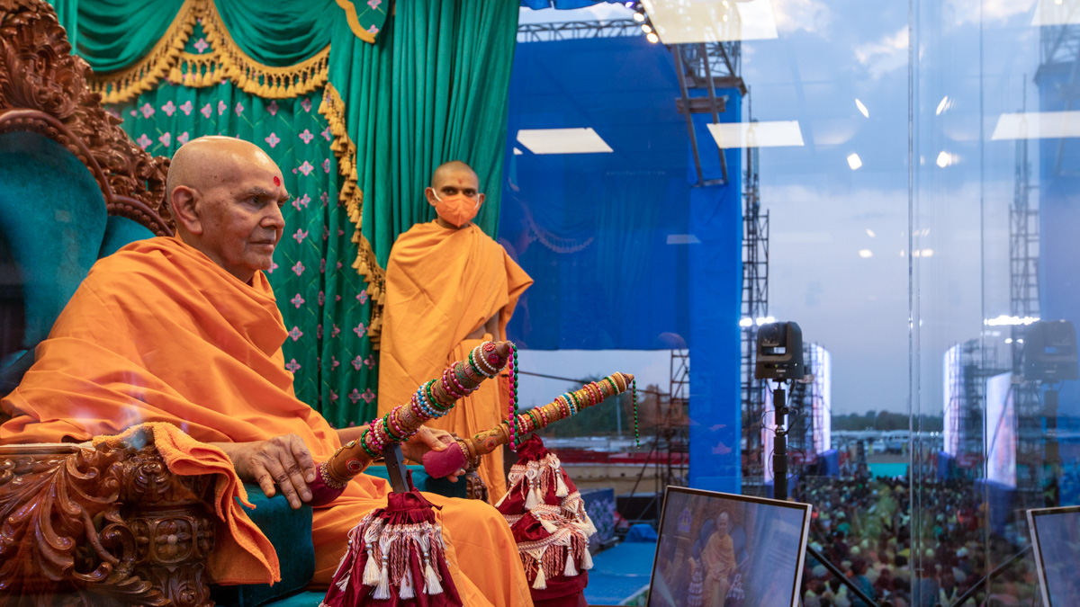 Swamishri sprays sanctified saffron-scented water on devotees