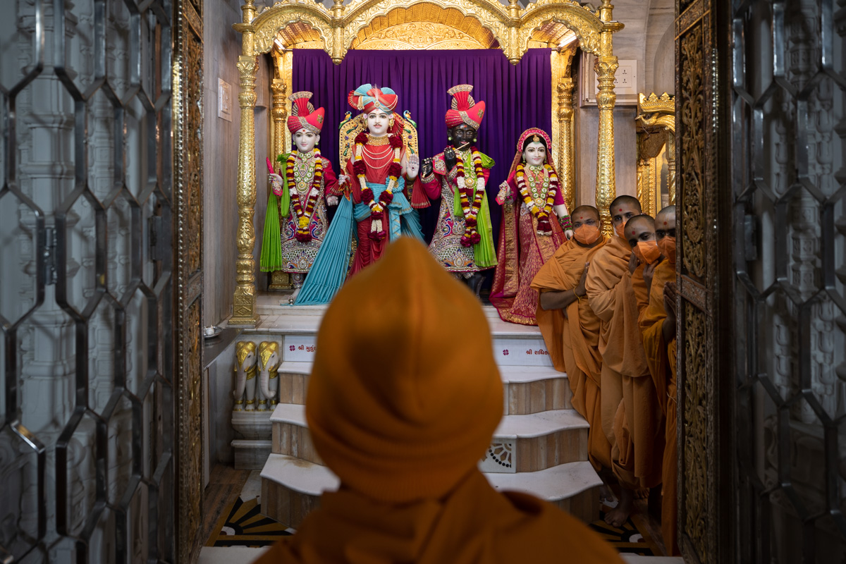 Swamishri engrossed in darshan of Shri Varninath Maharaj and Shri Gopinath Dev