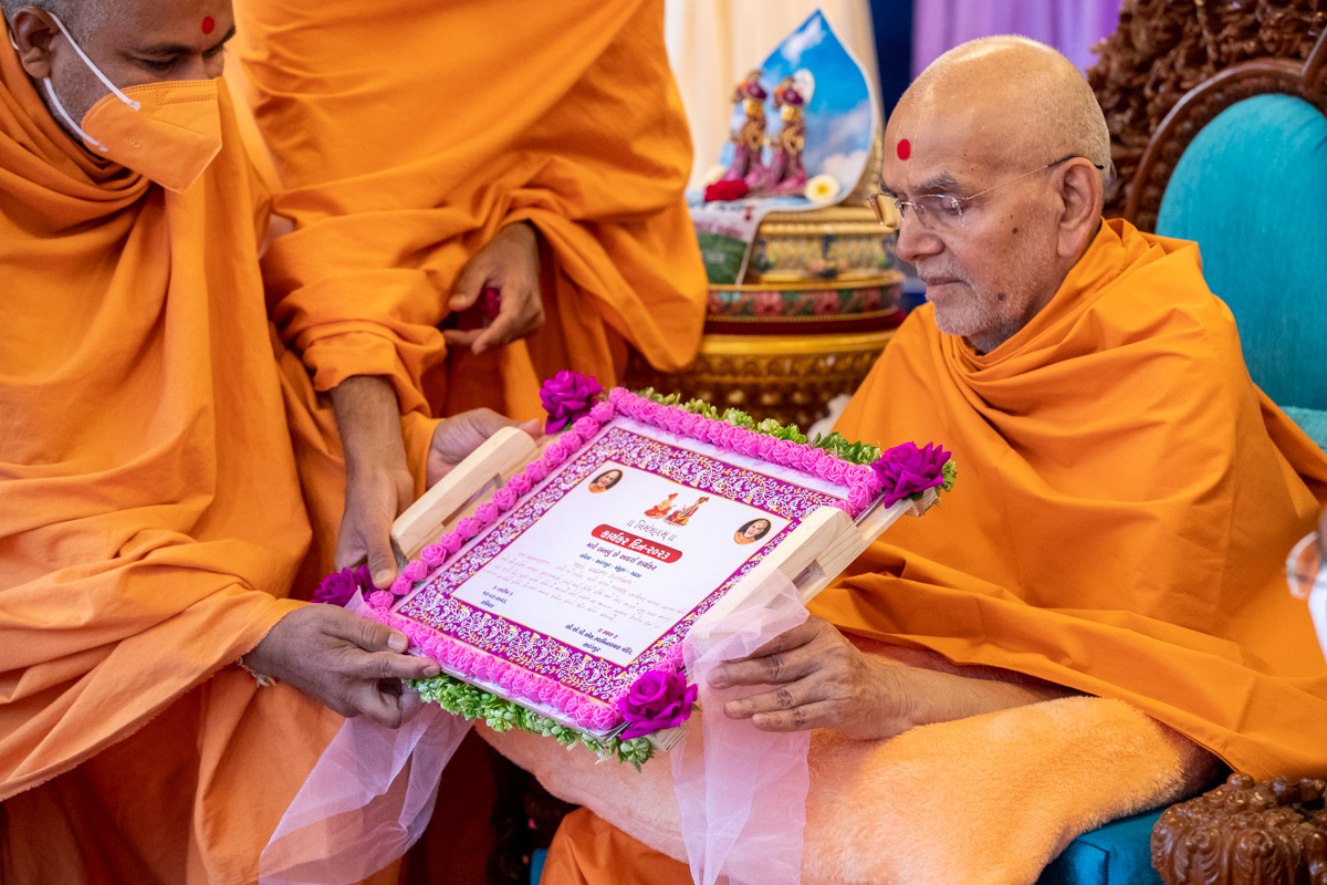 A sadhu gives an invitation for the Karyakar Din assembly to Swamishri