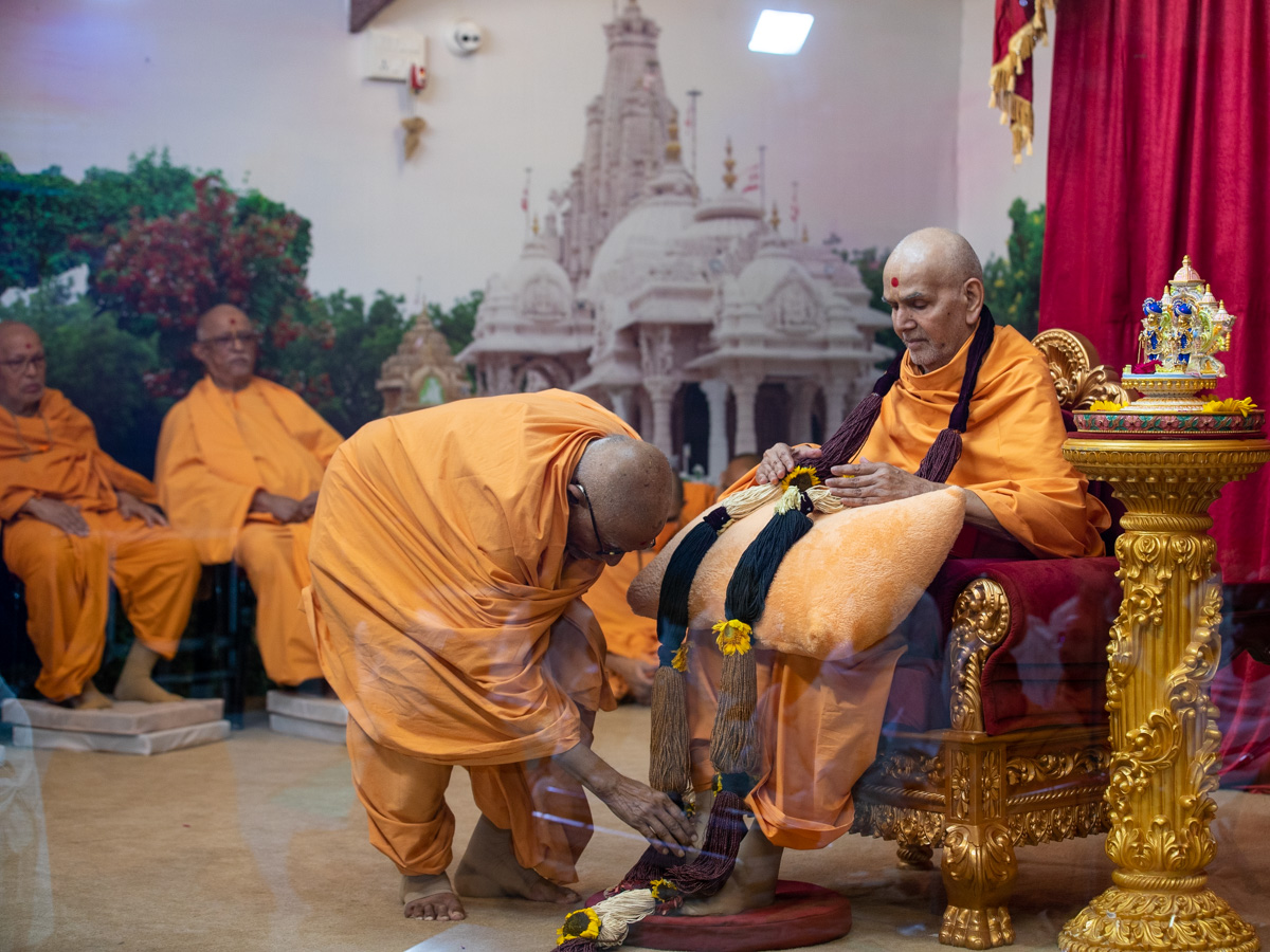 Pujya Bhaktipriya Swami (Pujya Kothari Swami) honors Swamishri with a garland