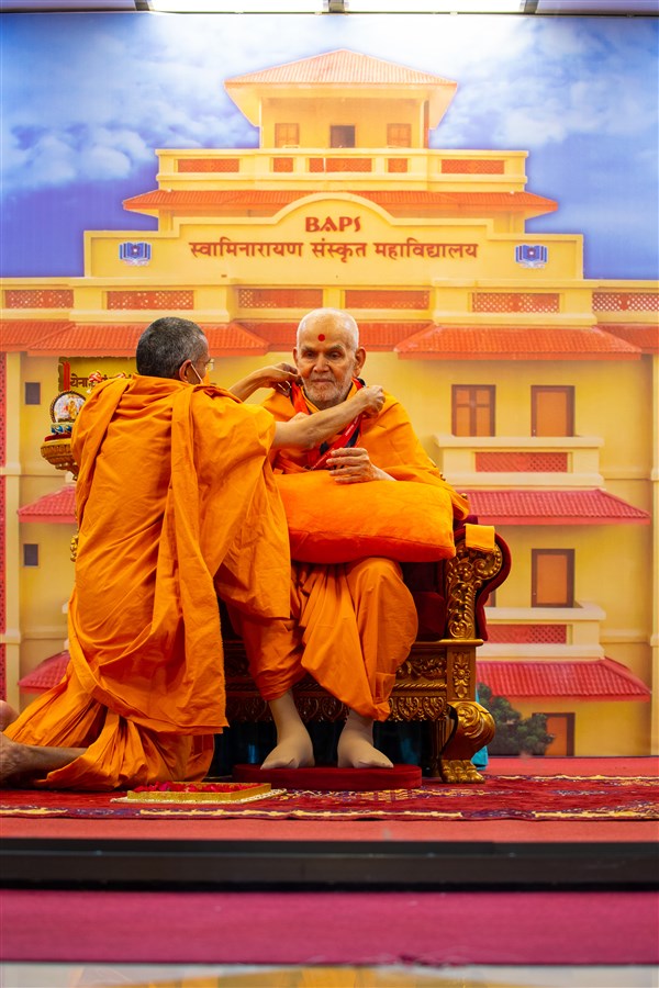 Atmatrup Swami offers an ID card to Swamishri