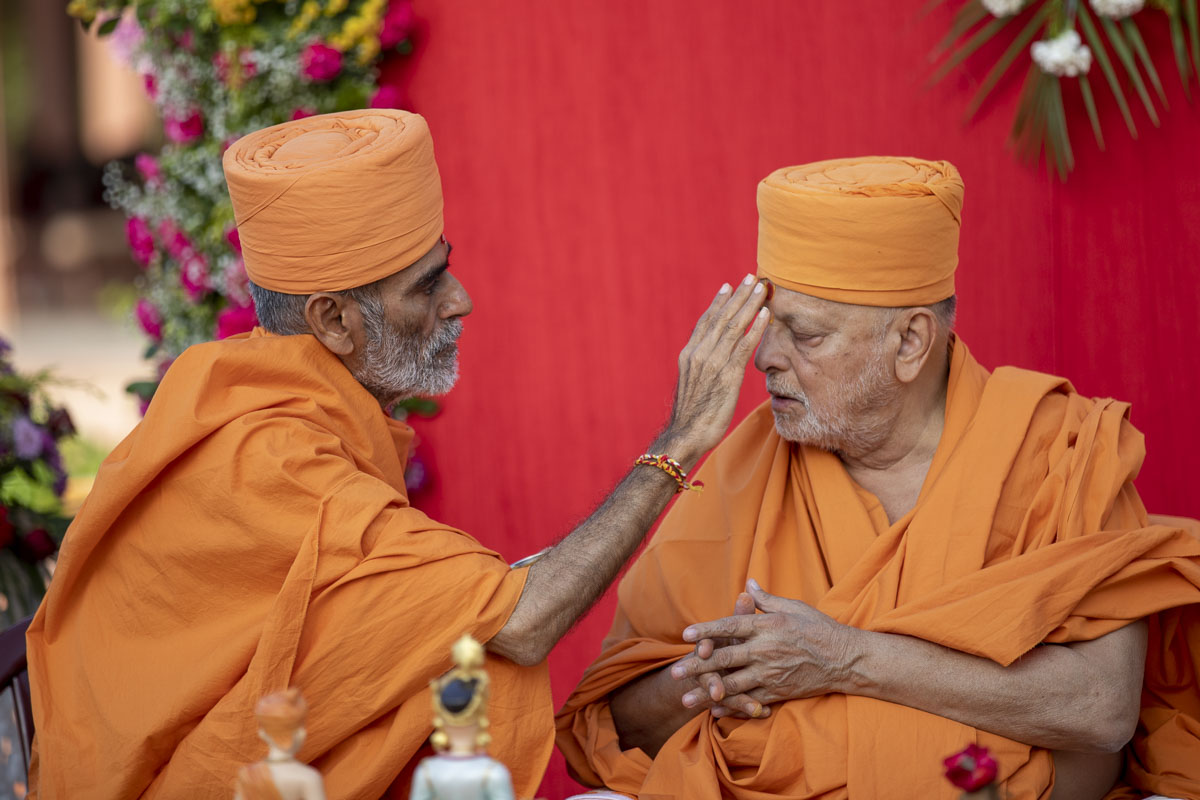 Anandswarup Swami applies a chandlo to Pujya Ishwarcharan Swami
