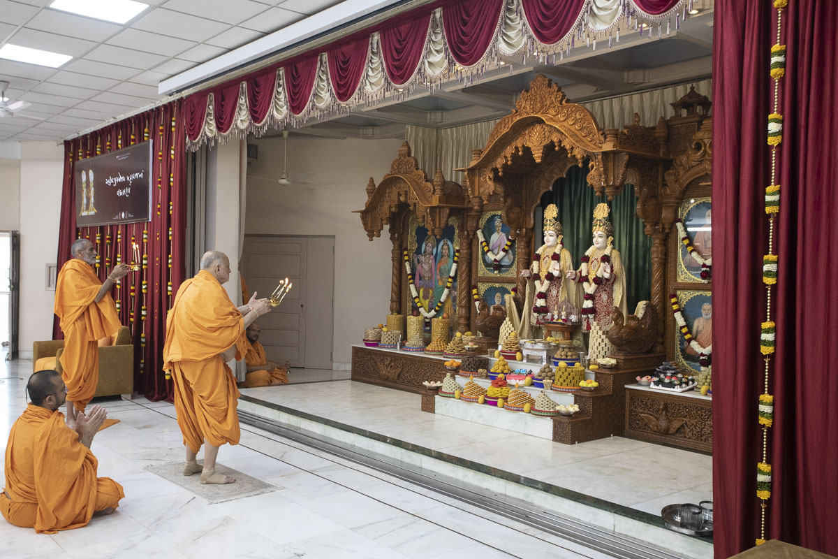 Pujya Ishwarcharan Swami and Anandswarup Swami perform the arti