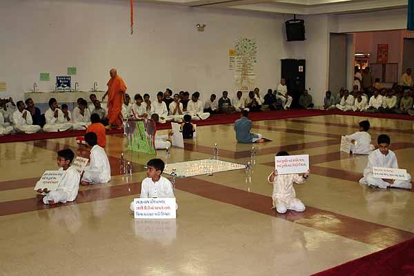 Balaks hold up signs of quotations from scriptures during Swamishri's walk 