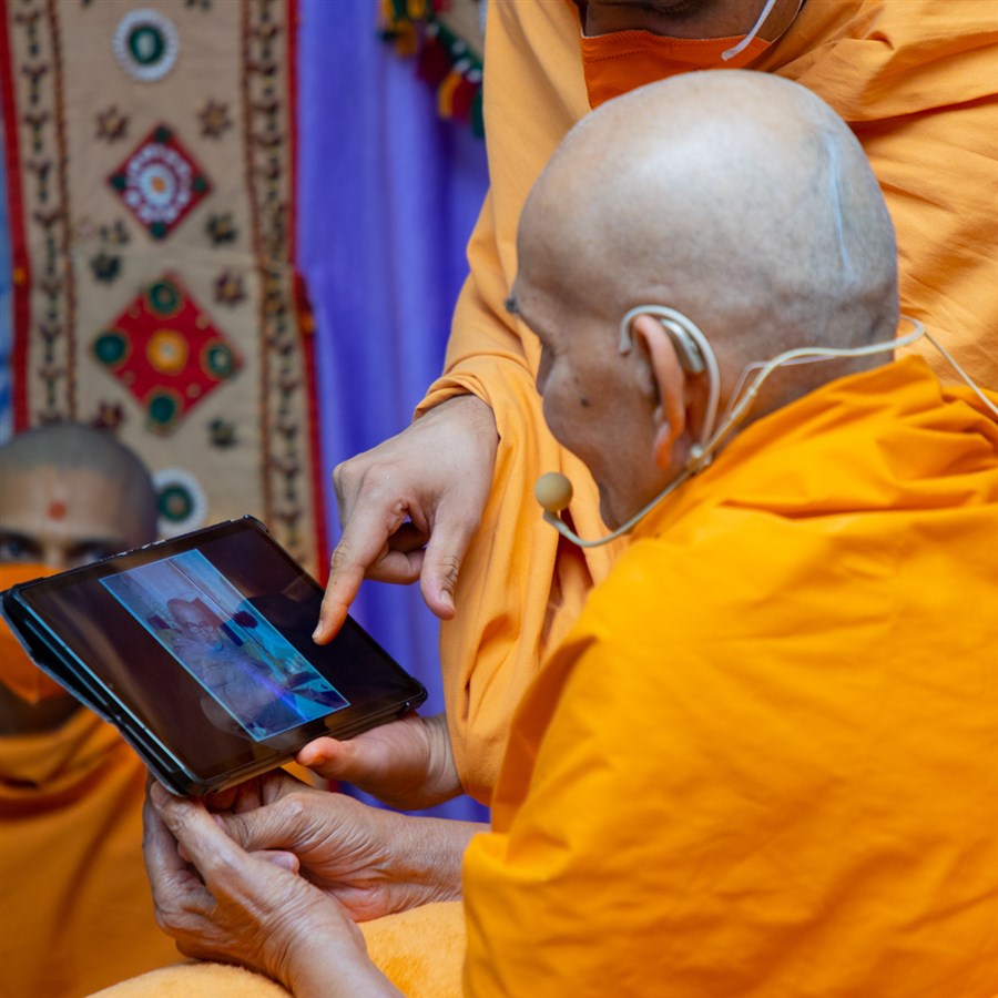 Swamishri observes a photo