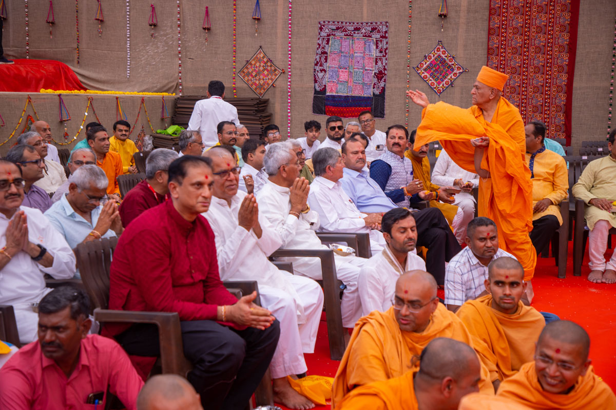 Bhagwatprasad Swami showers rice grains on devotees