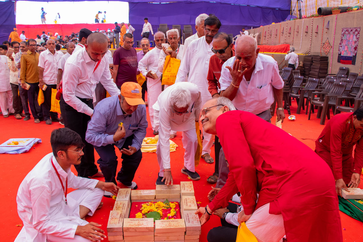 Devotees and well-wishers place bricks in the foundation