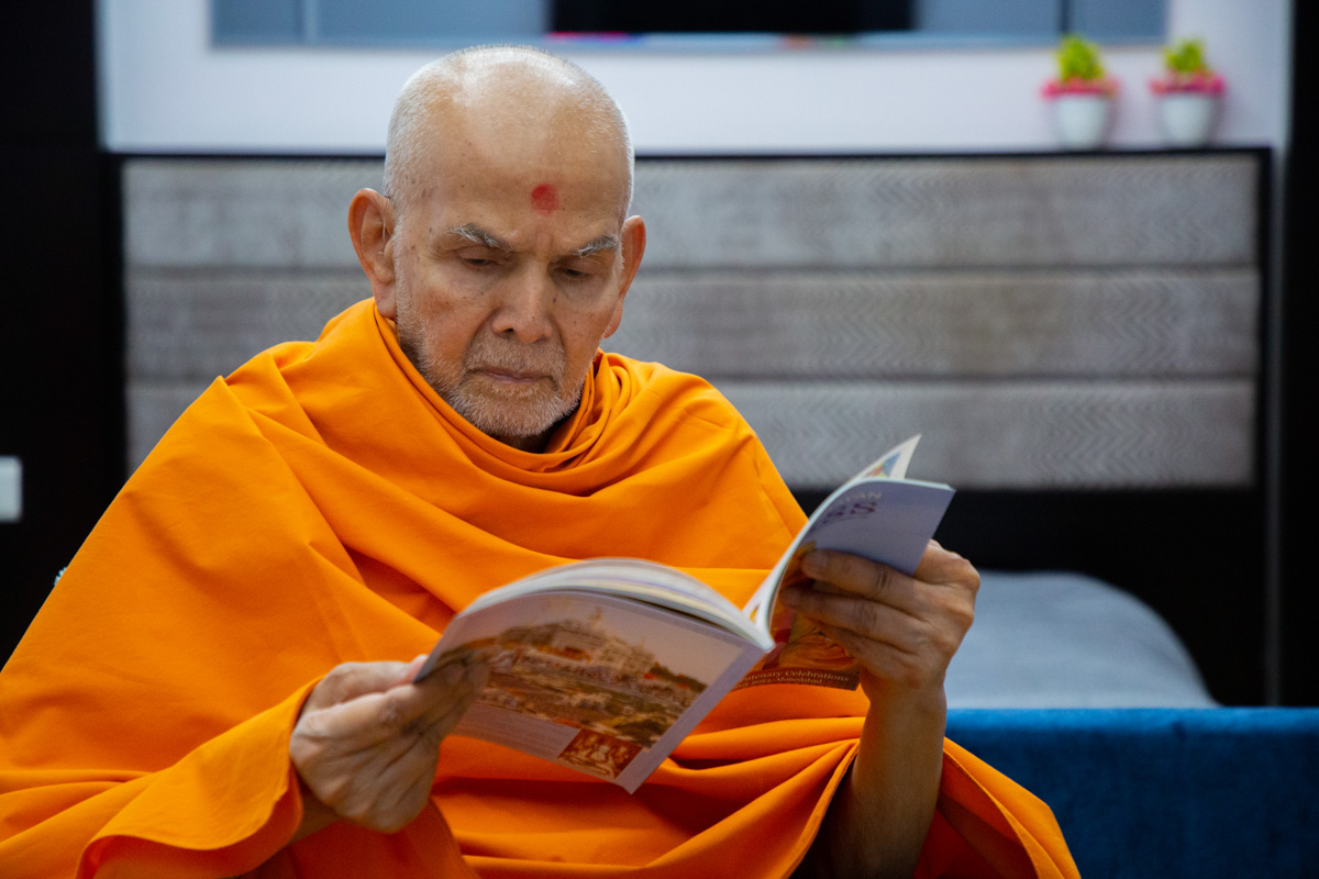 Swamishri reads the latest issue of 'Swaminarayan Bliss'
