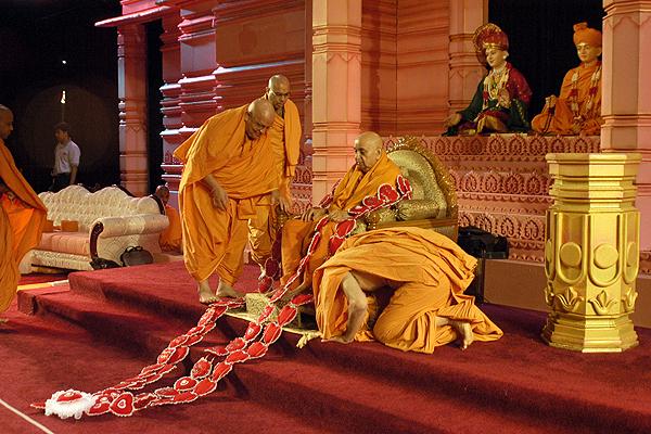 Senior saints present a garland of hearts to Swamishri 