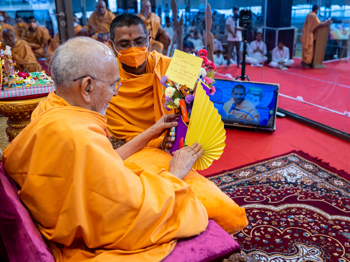 Swamishri sanctifies an invitation card for the Bal Din assembly