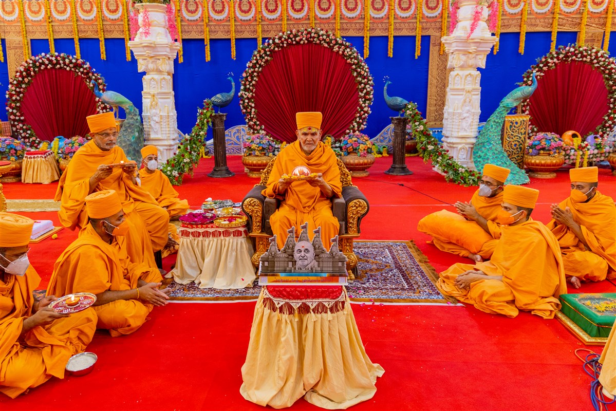 Swamishri and senior sadhus perform the arti