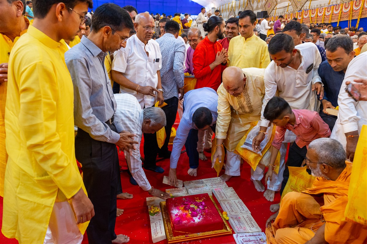Devotees place bricks in the foundation pit