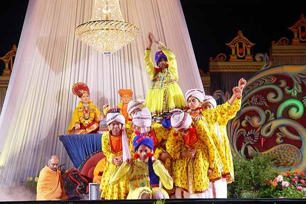 Balaks joyously welcome Swamishri with a cultural dance, 'Avya, Swami Avya Re Avya.'