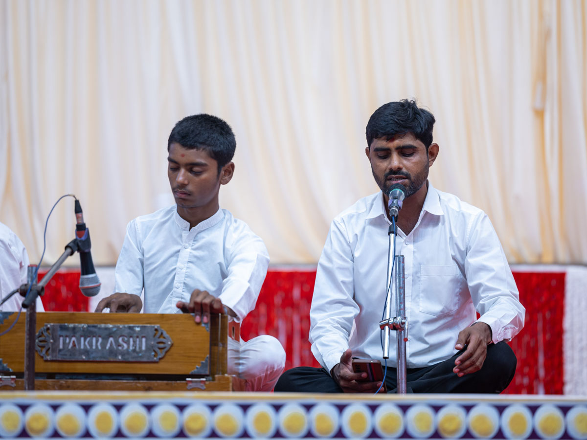 A youth sings a kirtan in the evening Bhakti Din assembly