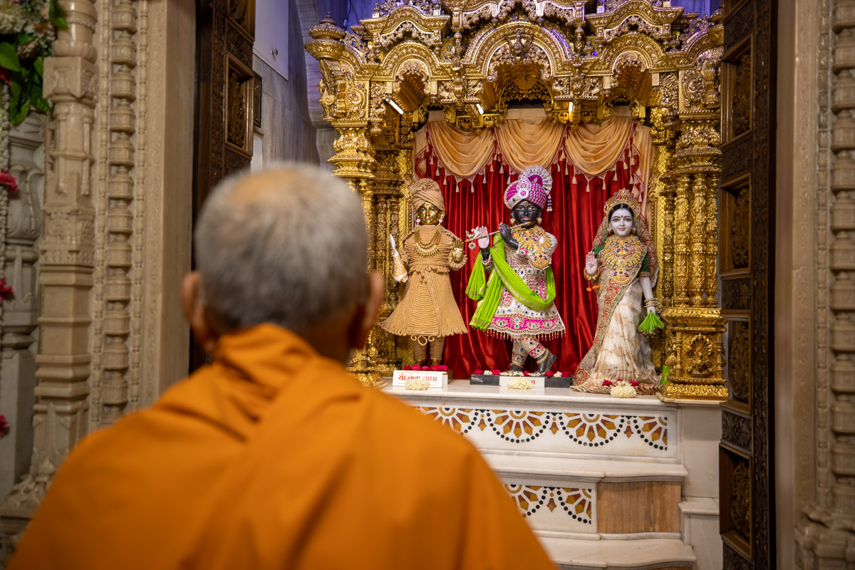 Swamishri engrossed in darshan of Shri Harikrishna Maharaj and Shri Radha-Krishna Bhagwan