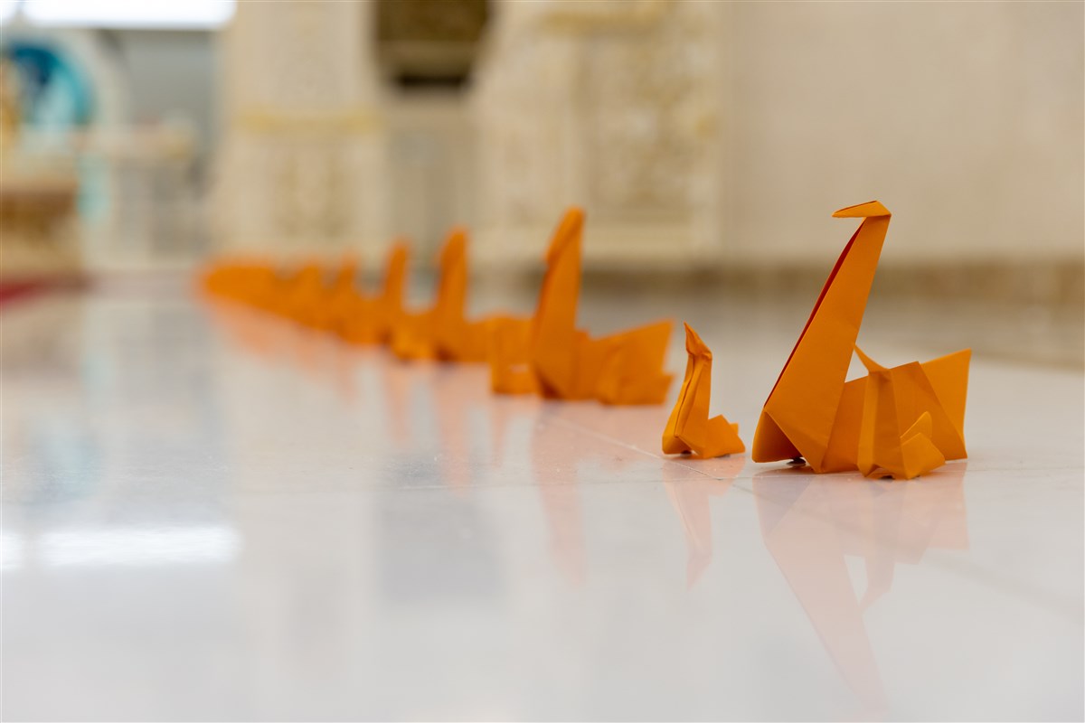 Swamishri’s path throughout the Mandir had been flanked by various origami (artistically folded paper) shapes symbolising various aspects of ‘The Divyabhav Project’ and ‘The Antardrashti Project’ that he had advised would be the best way to prepare for his visit<br>To learn more about this unique devotional welcome, please click <a href="https://www.baps.org/News/2023/Mahant-Swami-Maharaj-Joyously-Welcomed-at-BAPS-Shri-Swaminarayan-Mandir-London-23497.aspx" target="blank" style="text-decoration:underline; color:blue;">here</a>