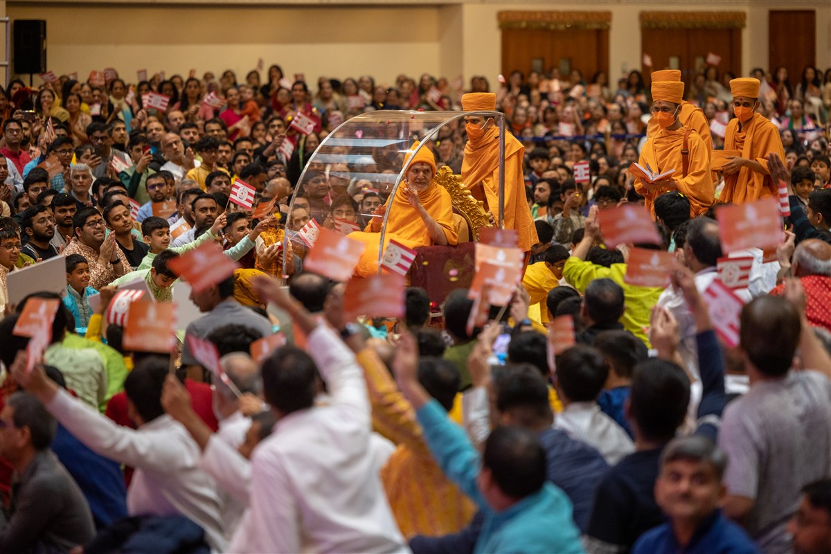 Swamishri entered through the central aisle, greeting children and devotees as he passed
