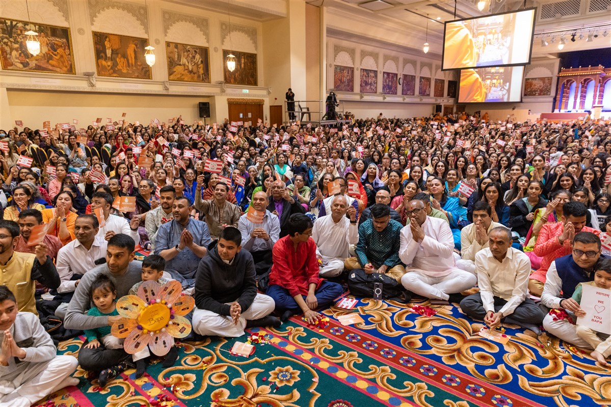 Devotees, who had arrived in the hall from the early hours of the morning, eagerly awaited Swamishri's entry