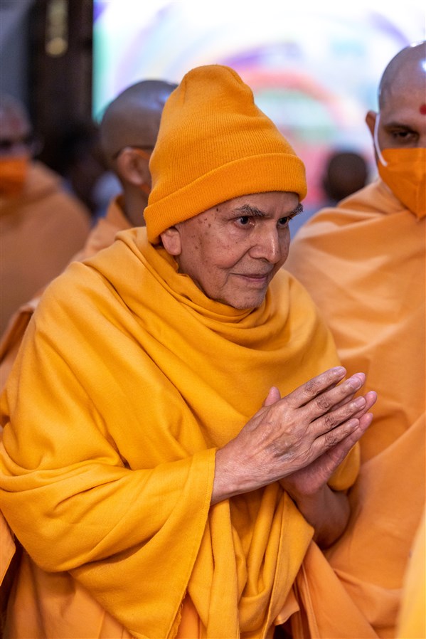 Swamishri greets everyone with folded hands as he enters the abhishek mandap