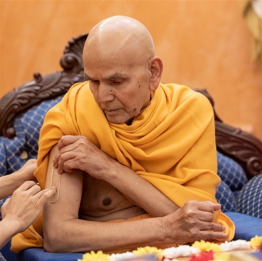 Swamishri commences his morning puja by applying a tilak on his arm