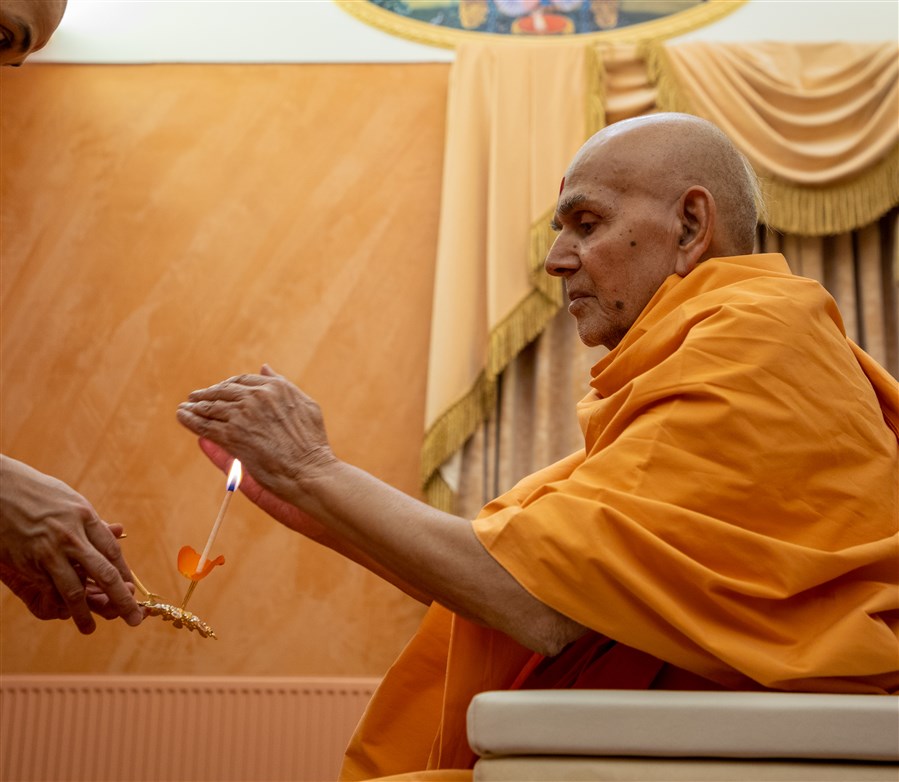 Swamishri accepts the blessings from the arti
