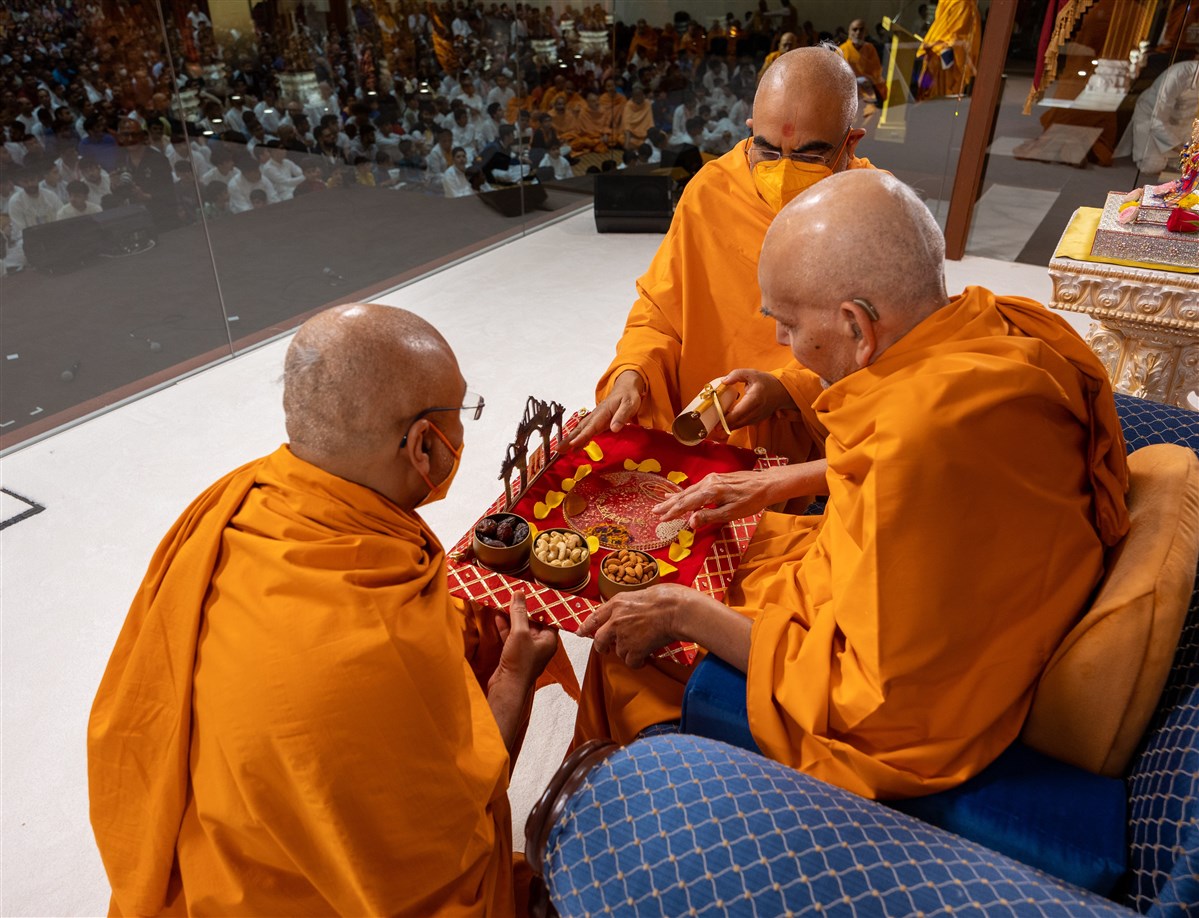 Swamis present a special devotional offering from the mahilas to Swamishri