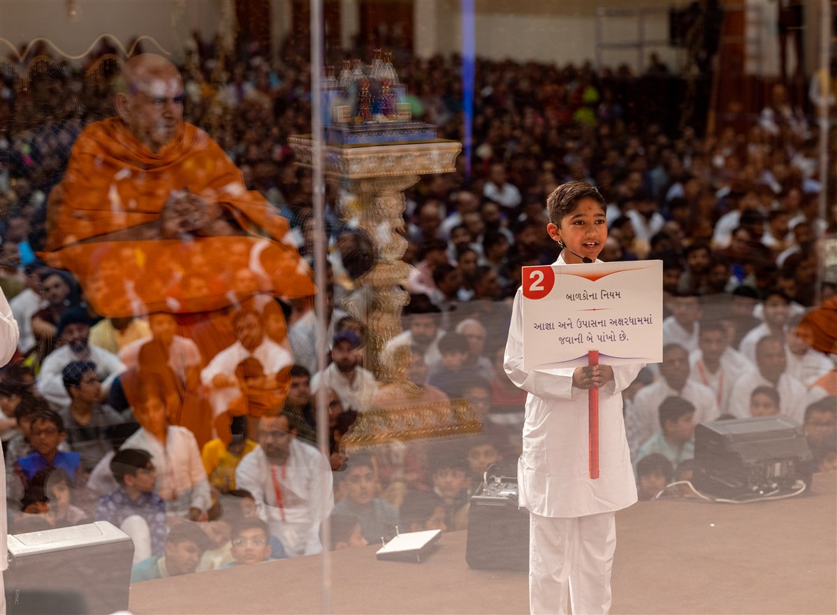 Swamishri listens attentively as a child recites passages from the Satsang Diksha