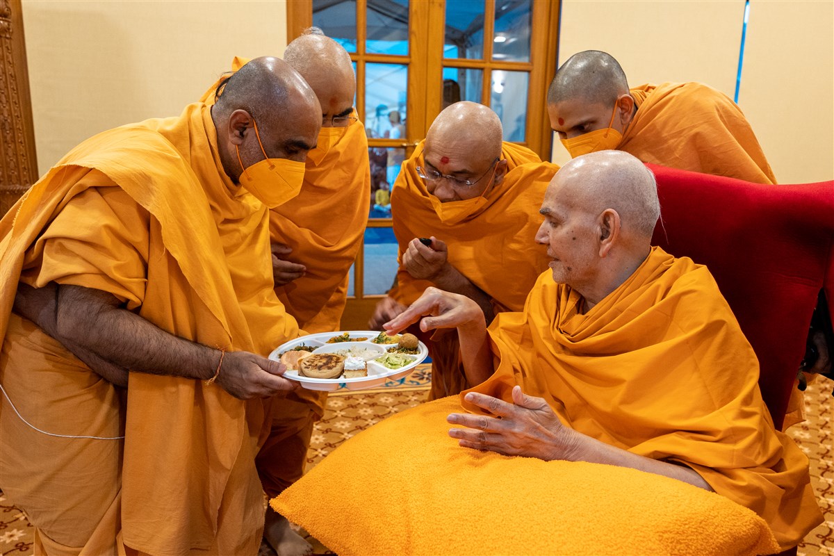 Swamishri observing a prasad plate for the devotees' evening mahaprasad