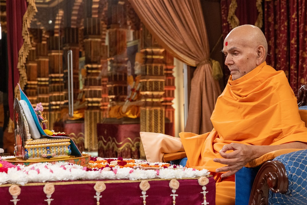 Swamishri turns the mala in his puja