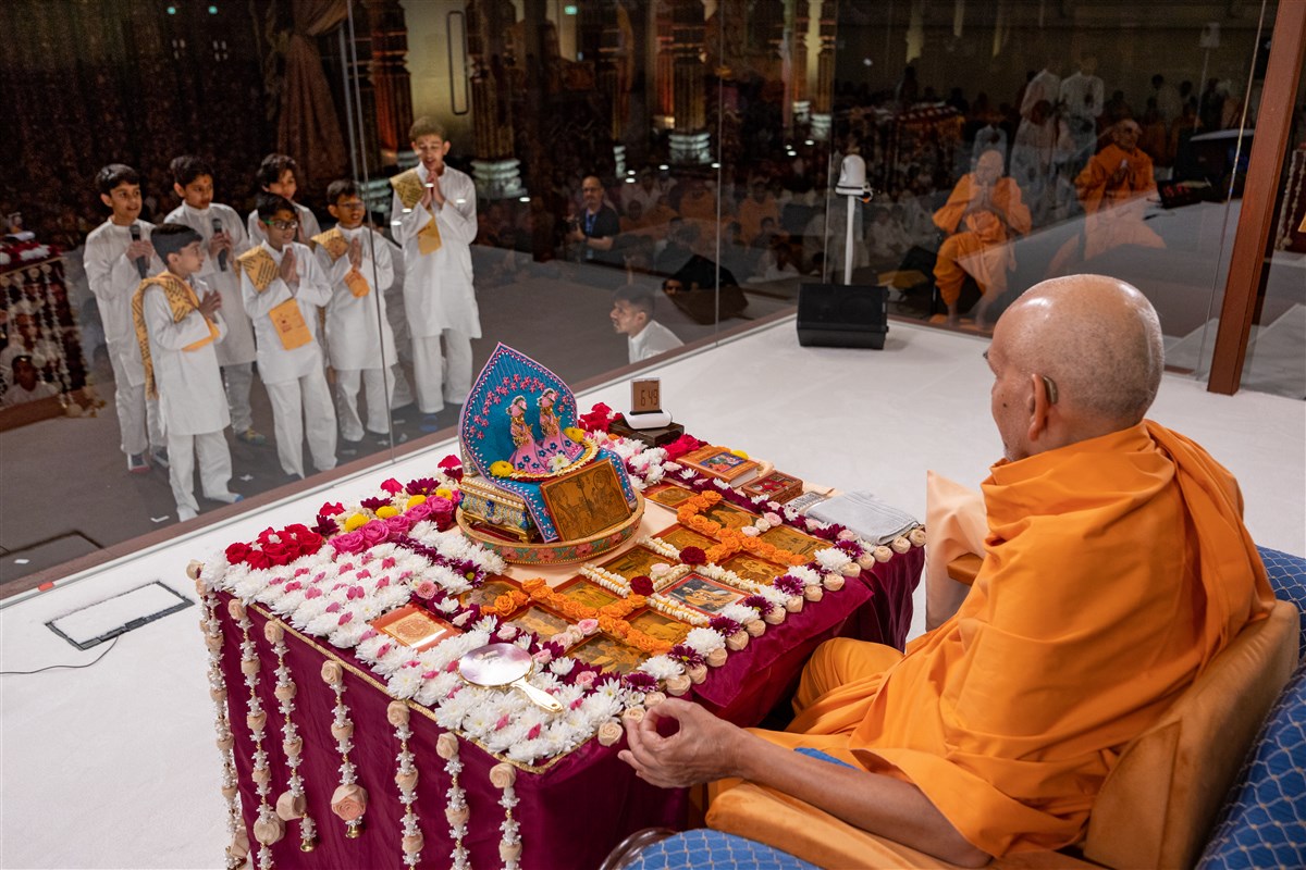 Children recite scriptural passages as Swamishri performs his puja