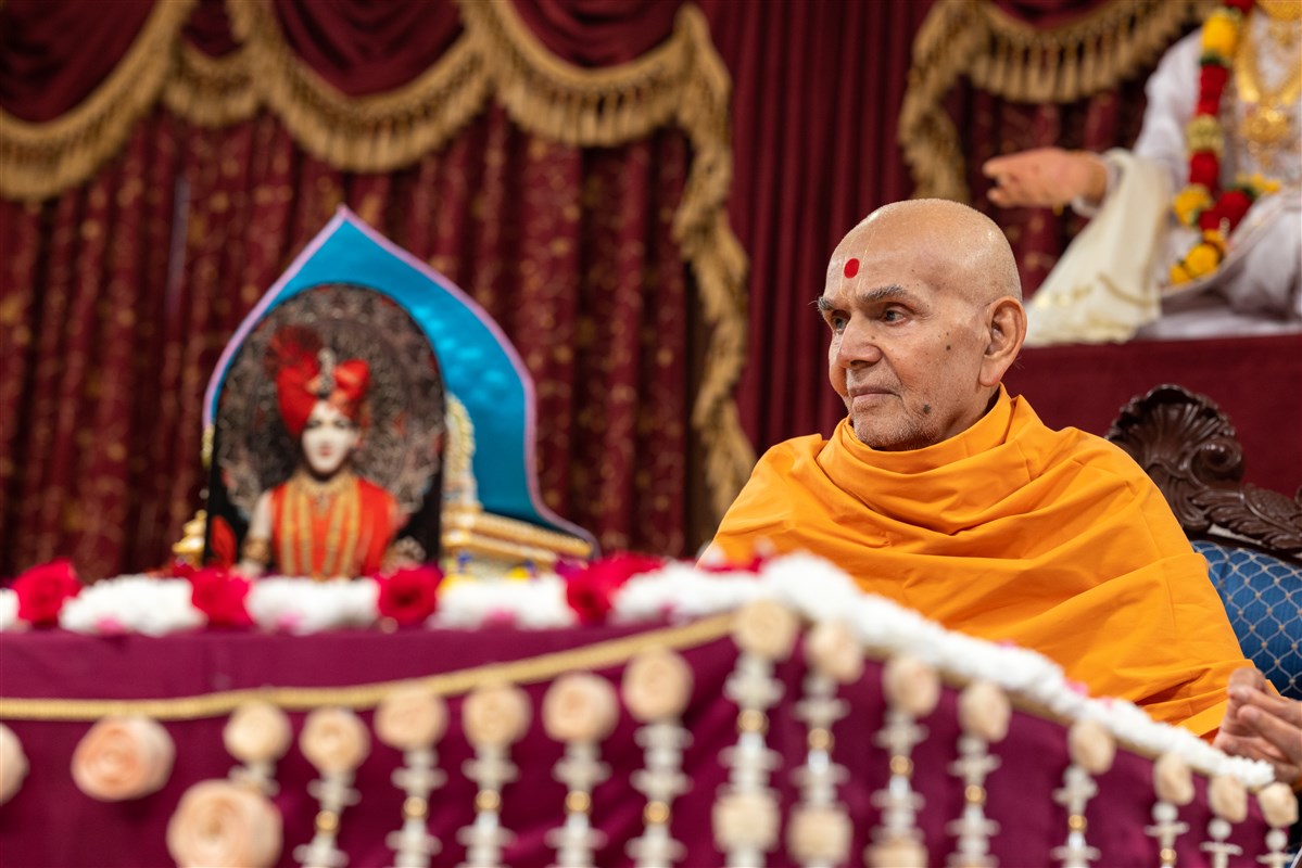 Swamishri listens attentively to the children's recital as he performs his puja