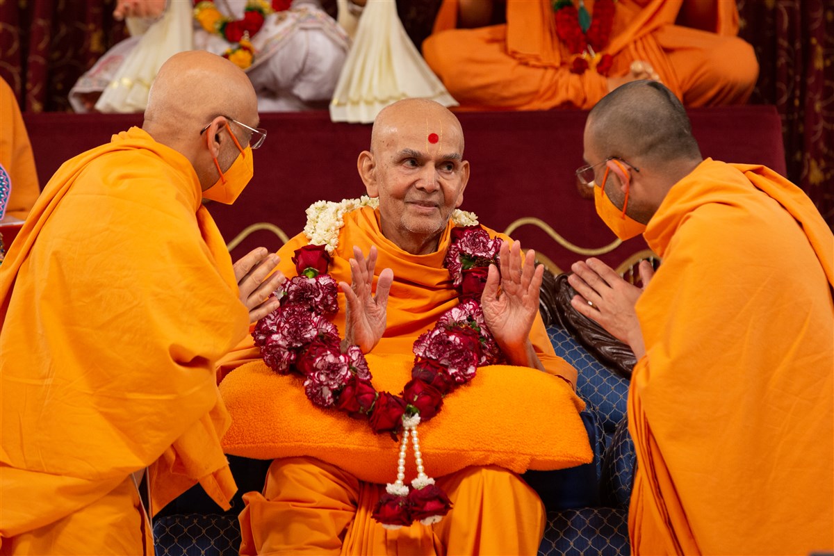 Tyagprakashdas Swami and Tyagratnadas Swami honour Swamishri with a flower garland