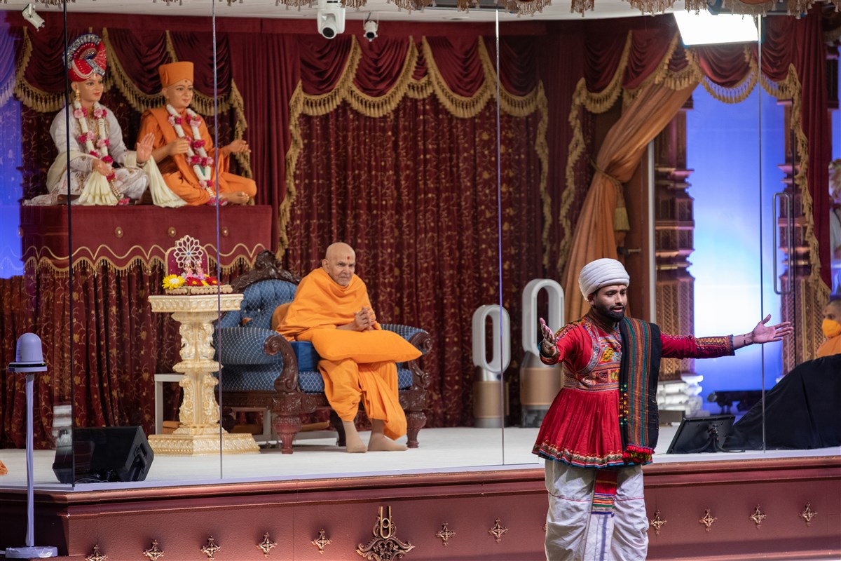 Swamishri listens attentively as a young performer explains the theme of the evening's welcome assembly