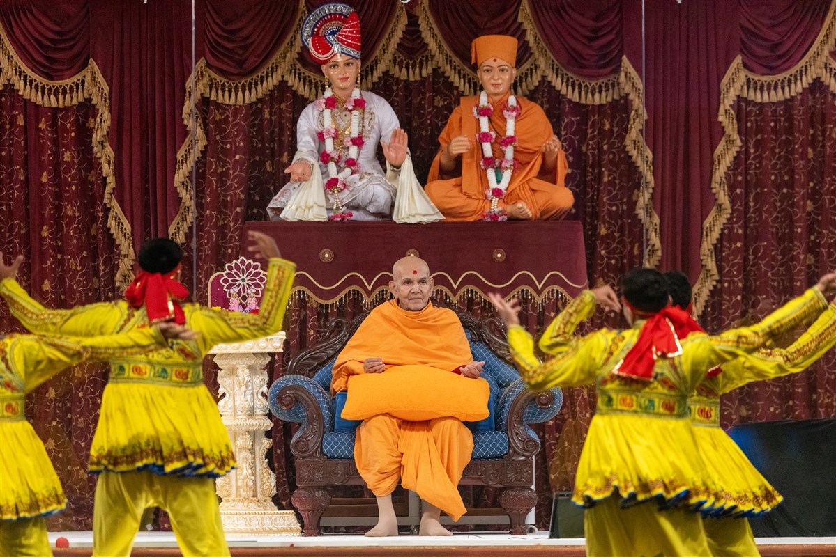 Swamishri watches attentively as youths perform a cultural welcome dance