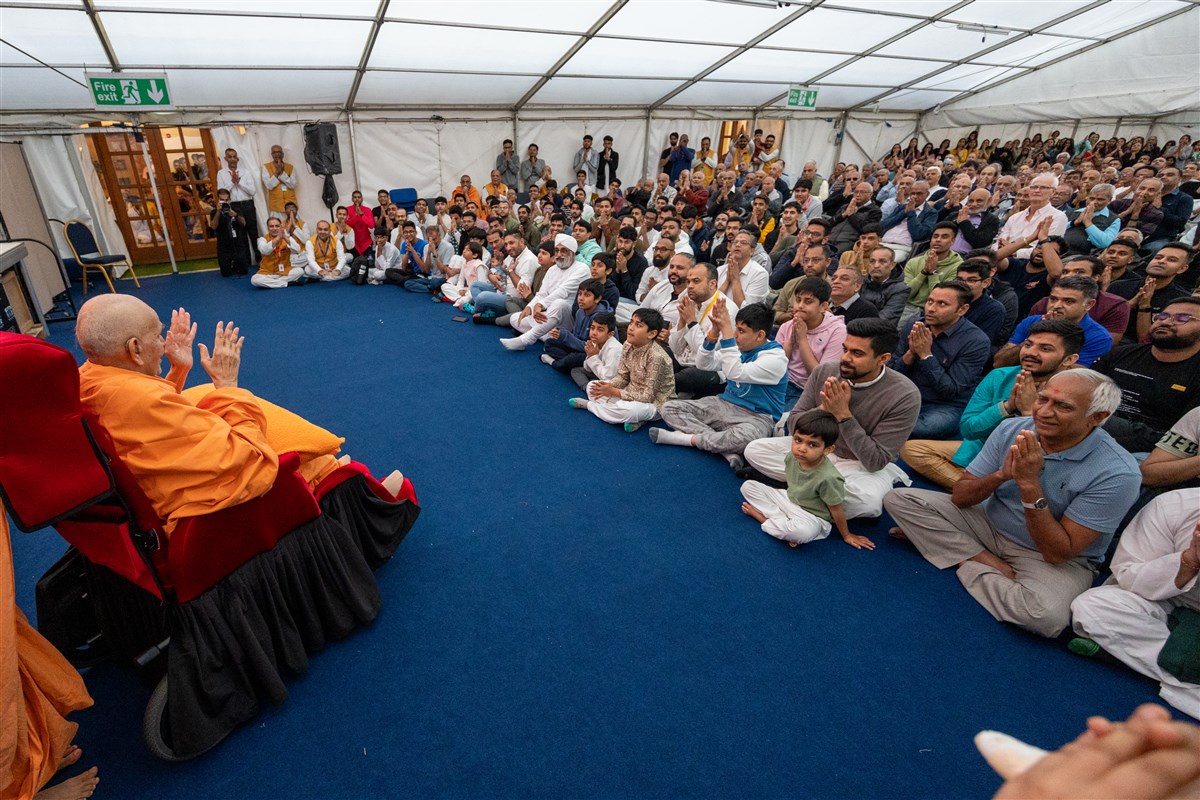 Swamishri blesses devotees seated in the overflow assembly area