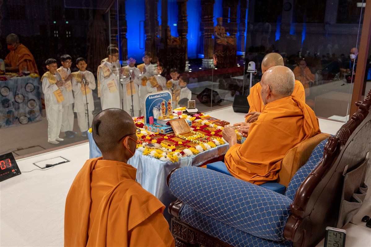Children recite scriptural passages as Swamishri performs his puja